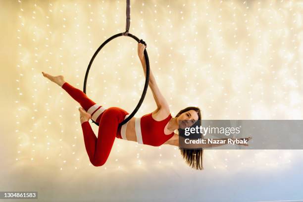 aerial dance performance with an aerial hoop against the beautiful illuminated background - acrobatic activity stock pictures, royalty-free photos & images