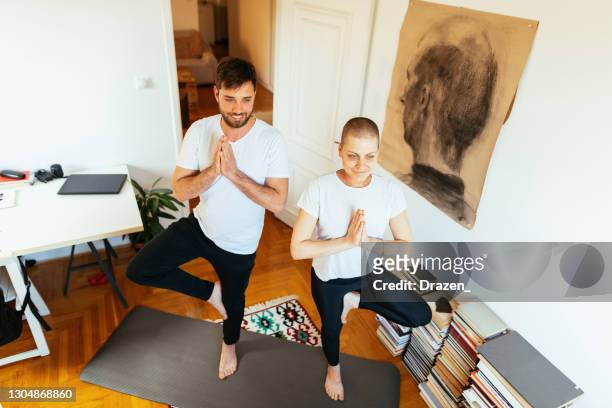 couples à la maison faisant le yoga à la maison - femme guérie de cancer et son exercice de mari ensemble - serbie photos et images de collection