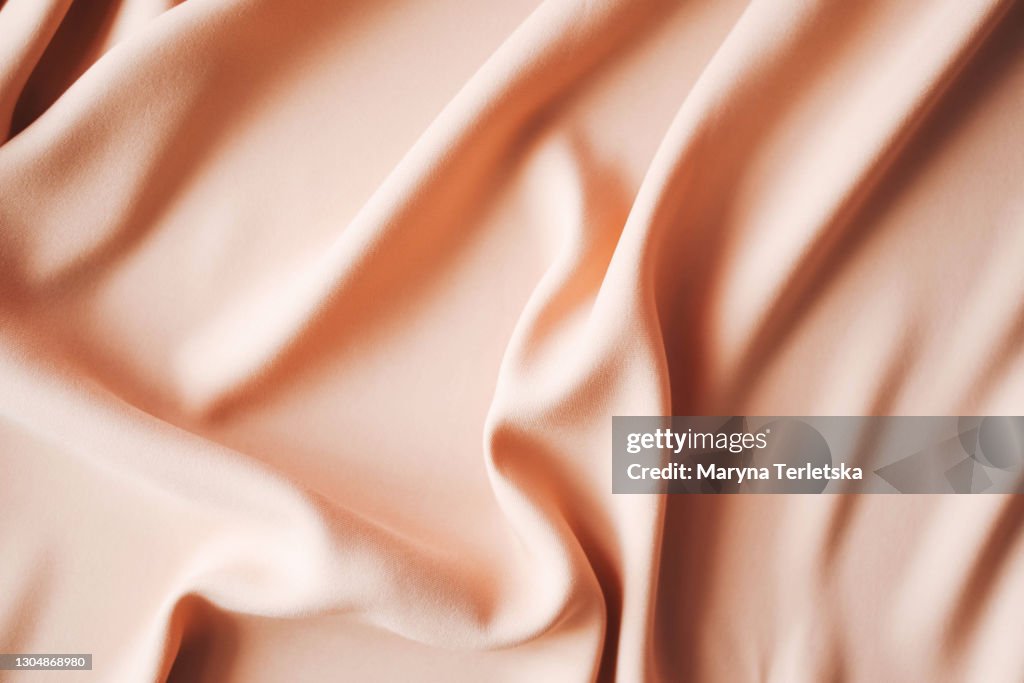 Background from satin fabric of peach color.