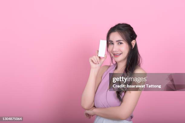 closeup portrait of beautiful young girl holding skincare cosmetics, box with face cream, serum. place for text, copyspace. concept photography for luxury natural cosmetics shop no brand - beauty cosmetic luxury studio background stock pictures, royalty-free photos & images