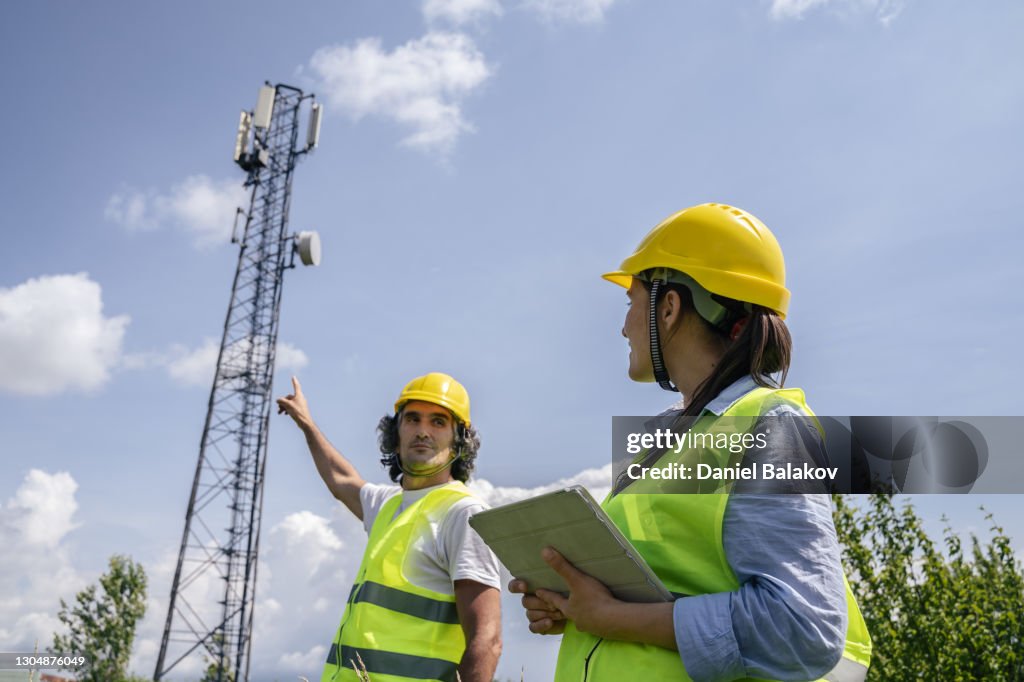 Engineers Working On The Field Near A Telecommunications Tower Teamwork ...