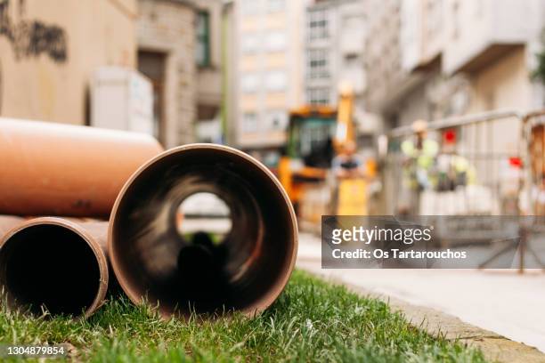 pipes for pipelines on the ground next to a construction site - canalisation stock-fotos und bilder