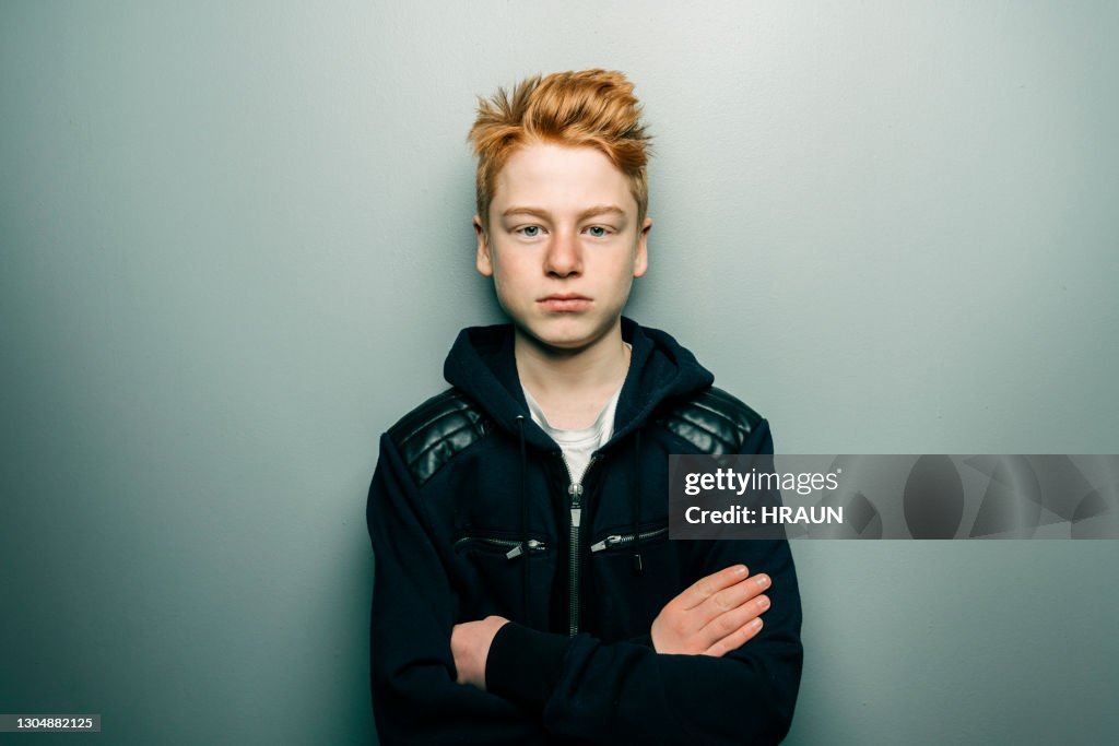 Young boy standing confidently with arms crossed