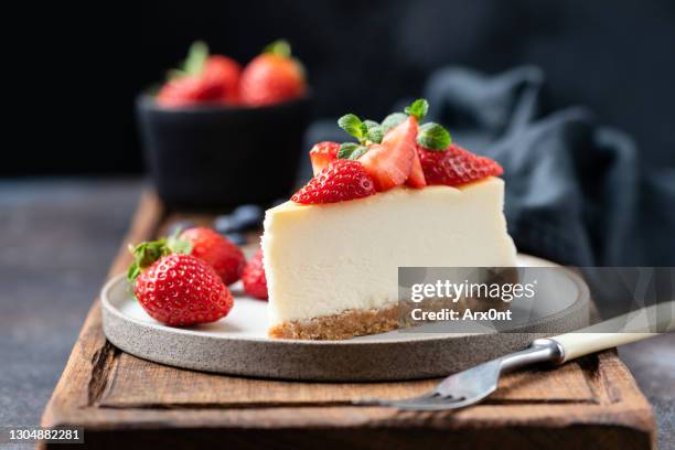 slice of cheesecake with strawberries - man eating pie stock-fotos und bilder