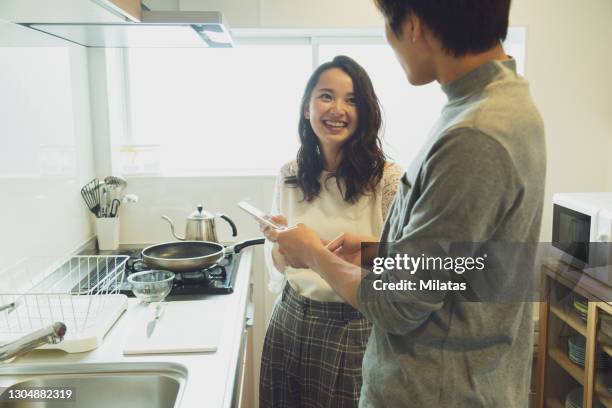 couple standing in the kitchen - 新婚ホヤホヤ ストックフォトと画像