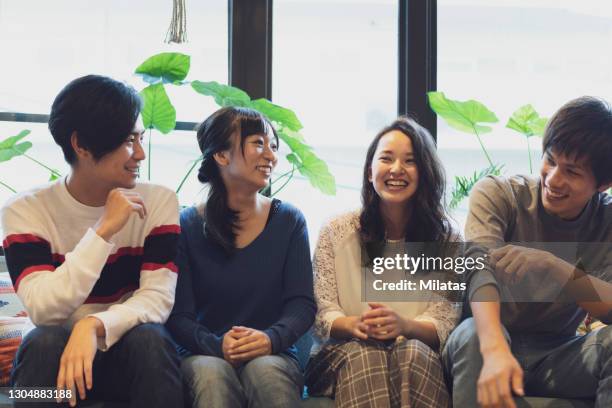 two couples chatting on the sofa - japanisch sprache stock-fotos und bilder