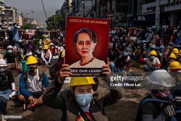 An anti-coup protester holds up a placard featuring de-facto leader Aung San Suu Kyi on March 02, 2021 in Yangon, Myanmar. Myanmar's military...