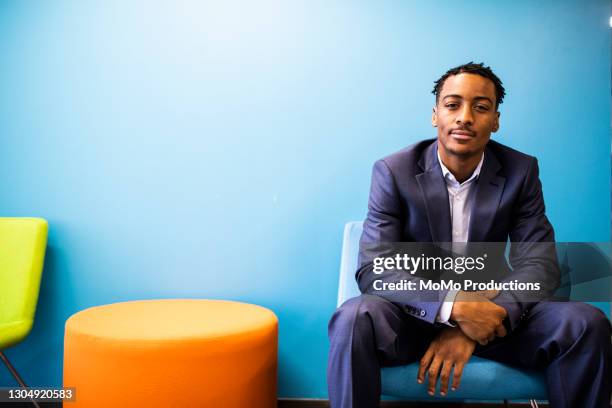 portrait of businessman in colorful modern office - staff benefits corporate stock-fotos und bilder