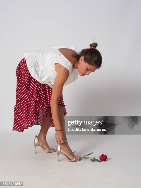 blonde woman dressed in flamenco plays, dances and smells a red rose - leather training shoes stock-fotos und bilder