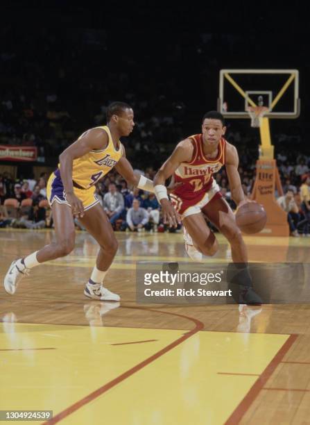 Doc Rivers, Point Guard for the Atlanta Hawks dribbles the basketball past Byron Scott of the Los Angeles Lakers during their NBA Pacific Division...