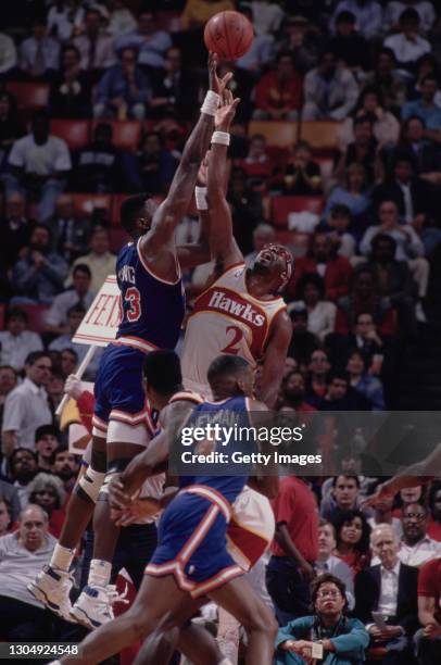 Moses Malone, Power Forward and Center for the Atlanta Hawks and Patrick Ewing of the New York Knicks reach for the basketball during their NBA...