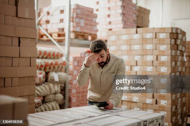 verwarde productiemanager die binnenshuis werkt - factory owner stockfoto's en -beelden