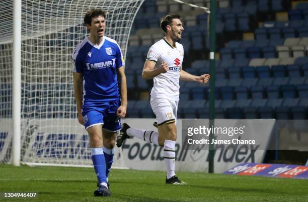 Warren O'Hora of Milton Keynes Dons celebrates after scoring his sides second goal as Thomas O'Connor of Gillingham FC reacts during the Sky Bet...
