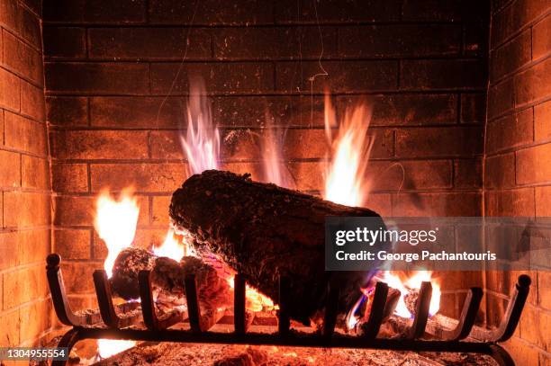 logs burning in a fireplace - wood burning stove stock-fotos und bilder