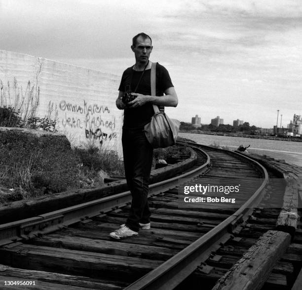 American photographer Peter Hujar poses for a portrait while standing on railroad tracks circa May, 1986 in Bayonne, New Jersey.