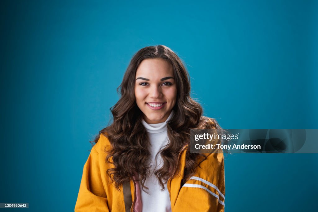 Portrait of young mixed race woman on blue background