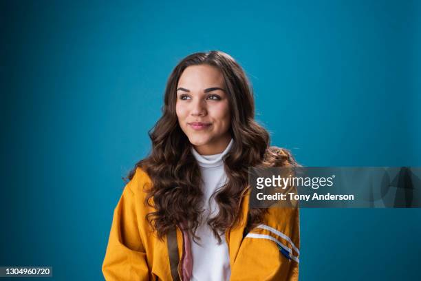 portrait of young mixed race woman on blue background - sonrisa satisfecha fotografías e imágenes de stock