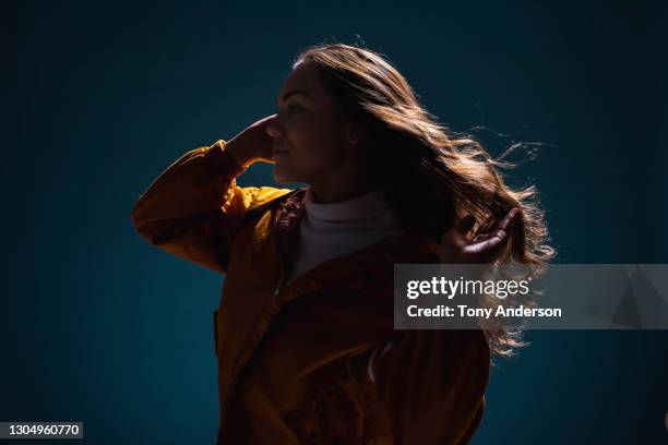 portrait of young mixed race woman on blue background - back lit stock pictures, royalty-free photos & images