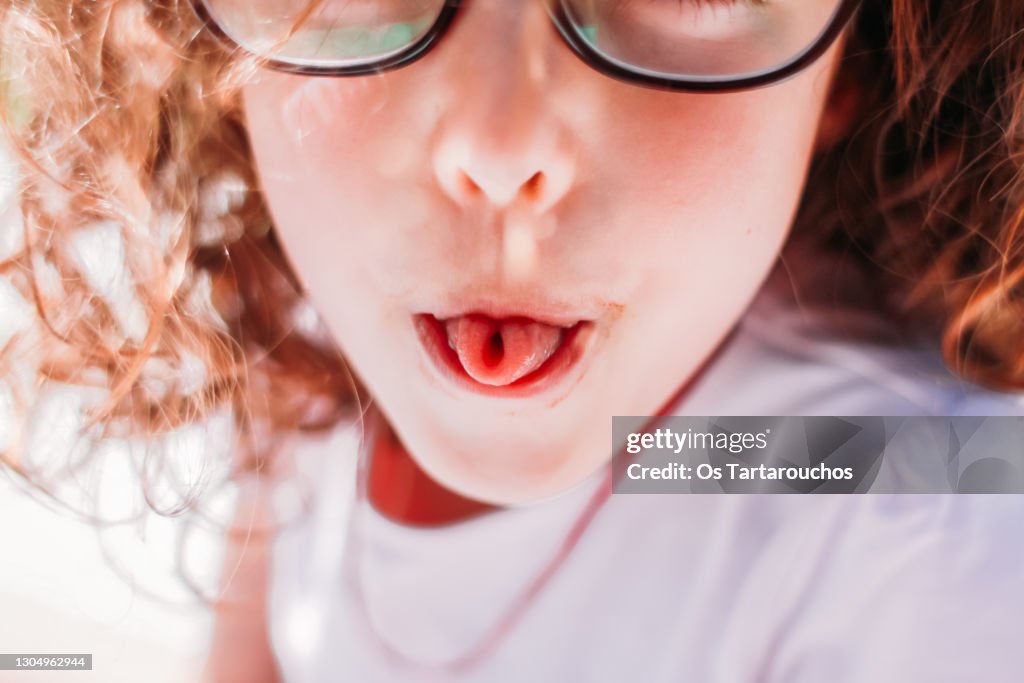 Girl rolling up her tongue like an u letter