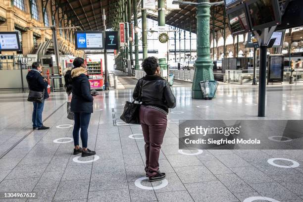 Passengers look at the train timetable on a screen on February 27, at the Gare du Nord railway station in Paris, France. Despite the development of...