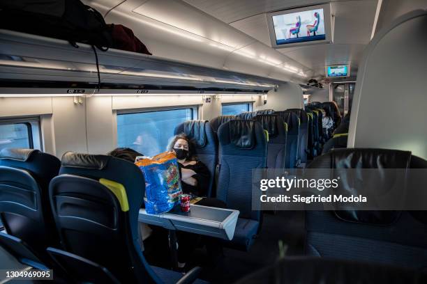 Woman sleeps on a high velocity train travelling to Amsterdam on February 27, 2021 close to the Brussels Midi railway station in Belgium. Despite the...