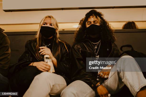 female friends sitting at subway during pandemic - generation z covid stock pictures, royalty-free photos & images