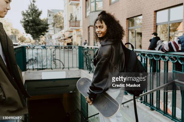 young friends standing on steps in city - berlin stock-fotos und bilder