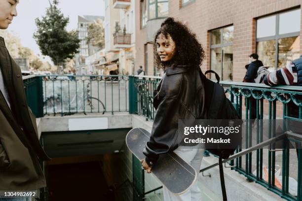 young friends standing on steps in city - ボード　持つ　女性 ストックフォトと画像