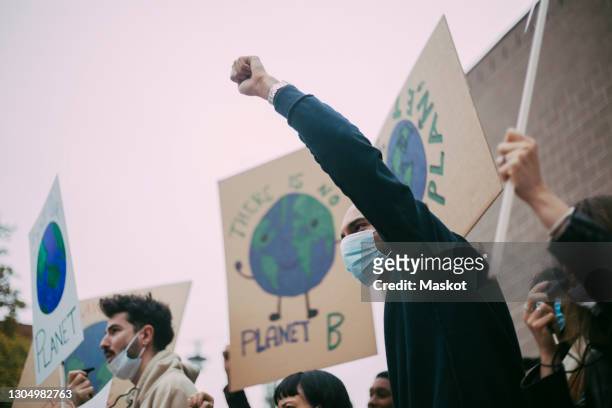 male activist protesting for environmental issues during pandemic - protest stock-fotos und bilder
