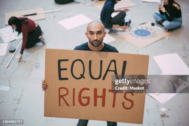 bald man with equal rights sign standing in building - free sign stock-fotos und bilder