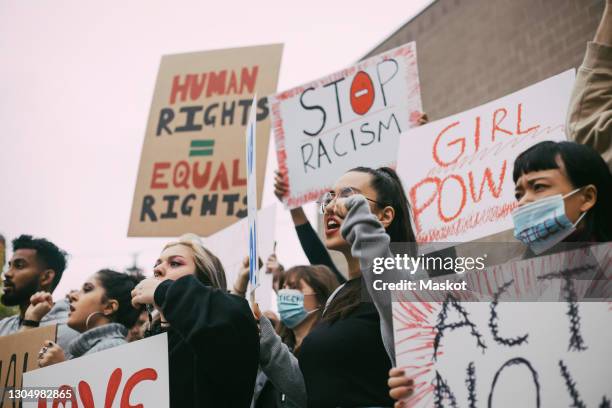 male and female activists protesting for human rights in social movement - manifestacion fotografías e imágenes de stock