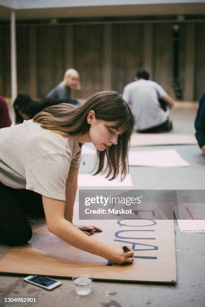 female protestor preparing signboard in building - activist stockfoto's en -beelden