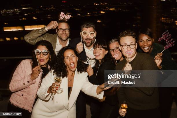 portrait of male and female colleagues with props in office at night - equipment launch party foto e immagini stock