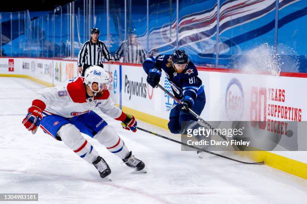 Shea Weber of the Montreal Canadiens and Kyle Connor of the Winnipeg Jets race to the puck along the boards during third period action at Bell MTS...