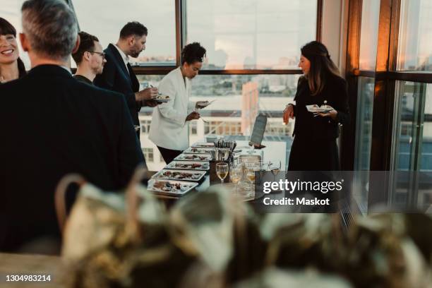 smiling business people having during office party - lunch photos et images de collection