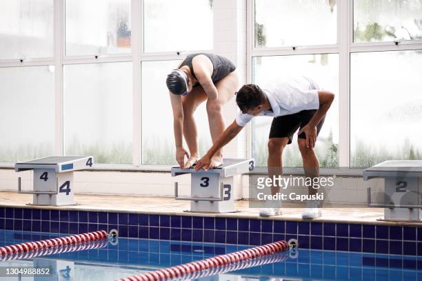 Entrenador dando instrucciones a nadador con discapacidades
