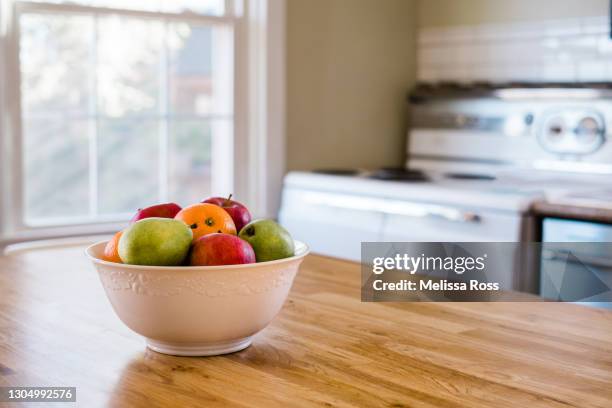 white bowl filled with fruit - kitchen table stock pictures, royalty-free photos & images