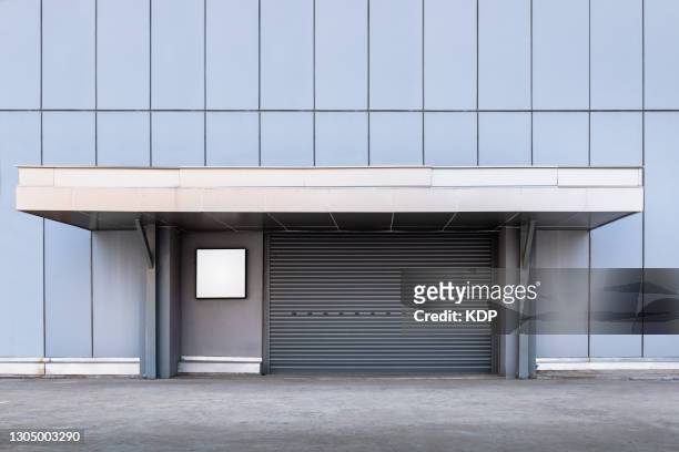 steel shutter rolling door of factory warehouse workshop for materials storage, front view of rolling metal doors for access and security. gate building structure of warehouses - door canopy stock pictures, royalty-free photos & images