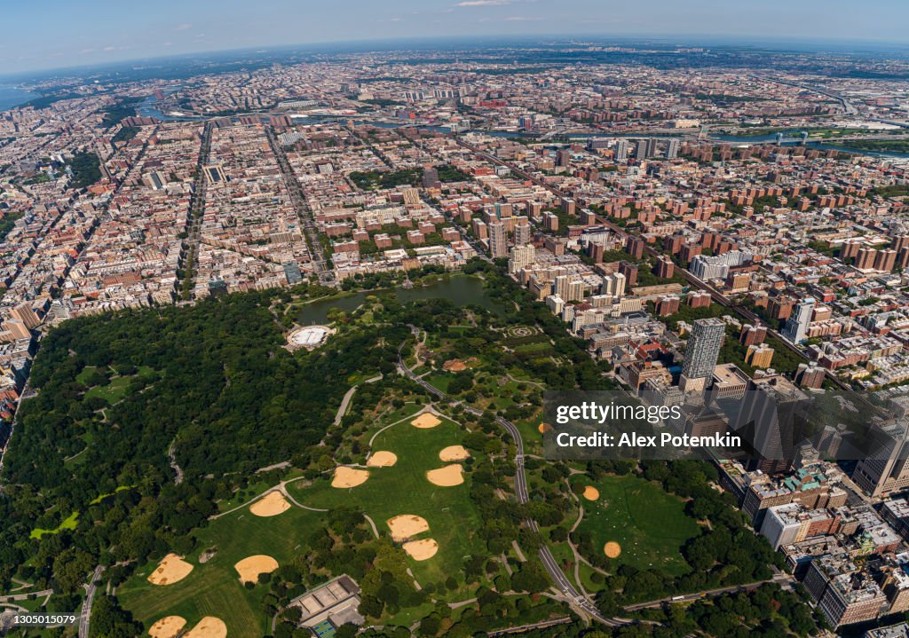 Aerial view of Central Park, Manhattan, and Harlem, and The Bronx in a distance behind, from a helicopter on a sunny summer day.