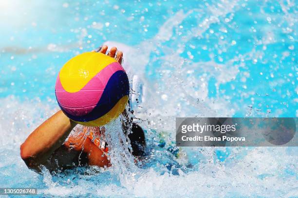 unknown sportsman holding a water polo ball above the water - waterpolo imagens e fotografias de stock
