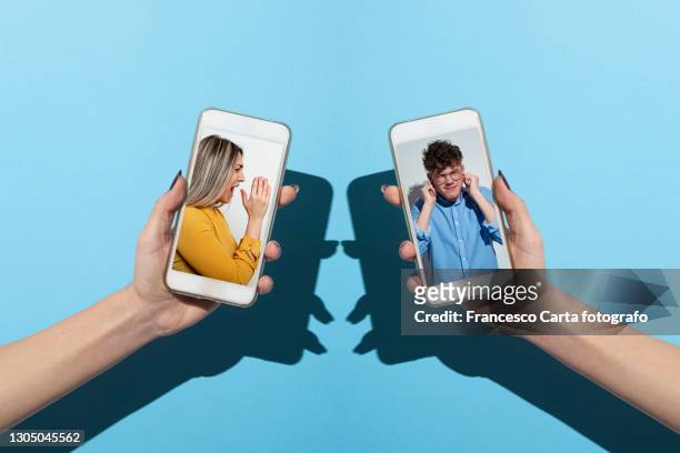 young couple arguing through a smartphone - couple relationship difficulties stock pictures, royalty-free photos & images