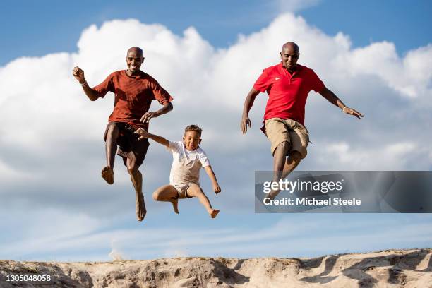 Mo Farah, son Hussein and twin brother leap over the sand dunes at Frensham Great Pond on July 12, 2019 in Farnham, England. This image is part of a...