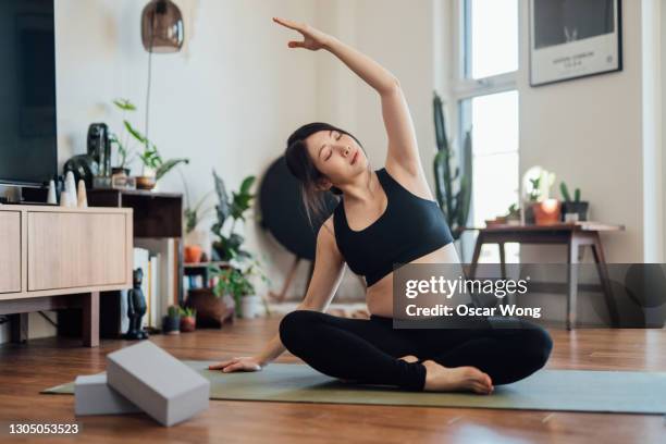 pregnant woman practices yoga at home - pregnant yoga stock-fotos und bilder