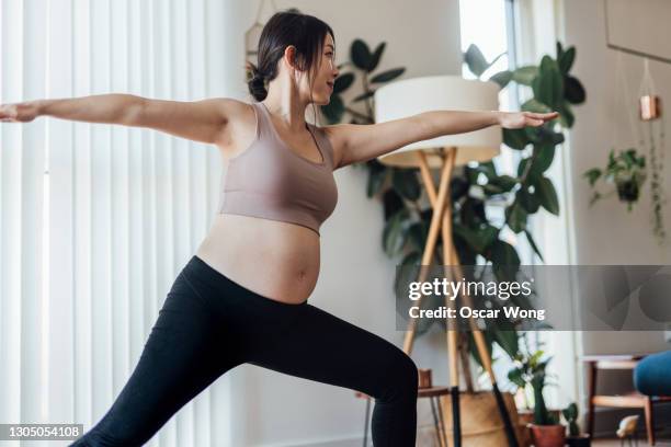 pregnant woman practices warrior 2 at yoga studio - equilíbrio vida trabalho - fotografias e filmes do acervo