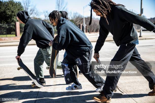 young men skateboarding through downtown area - center athlete stock pictures, royalty-free photos & images