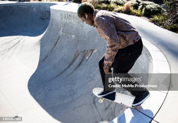 skateboarder skating empty pool in skatepark - skateboard rampe stock-fotos und bilder