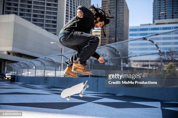 skateboarder performing trick in downtown atlanta - skating stock pictures, royalty-free photos & images