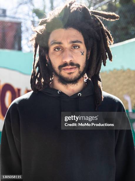 portrait of skateboarder at skatepark - tattoo man stock pictures, royalty-free photos & images