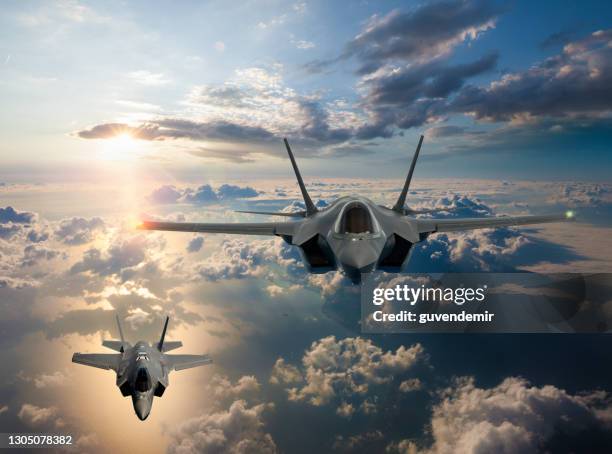 stralen die over de wolken bij zonsondergang vliegen - gevechtsvliegtuig stockfoto's en -beelden