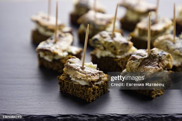 small sandwiches mini canapes with canned fish and cream cheese on black slate stone background - mackerel - fotografias e filmes do acervo